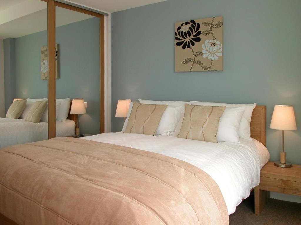圣赫利尔泽西Liberty Wharf Apartments的一间卧室配有一张大床和两盏灯。