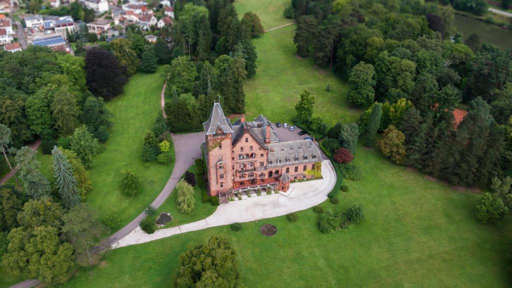 梅特拉赫Gästehaus Schloss Saareck的绿色田野上大房子的空中景色