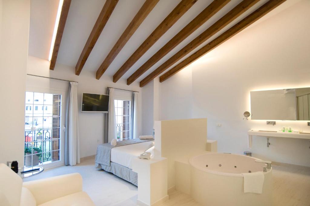 马翁Sindic Hotel - Adults Only的白色卧室设有1张床和1个浴缸