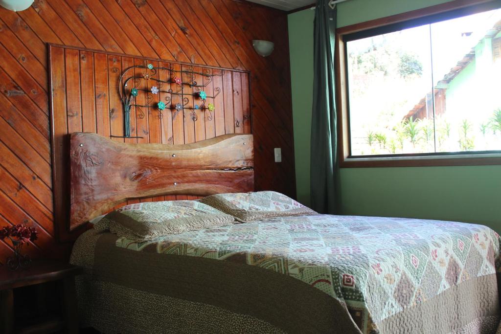 维奥康德马奥Suite JC的一间卧室设有一张床和木墙