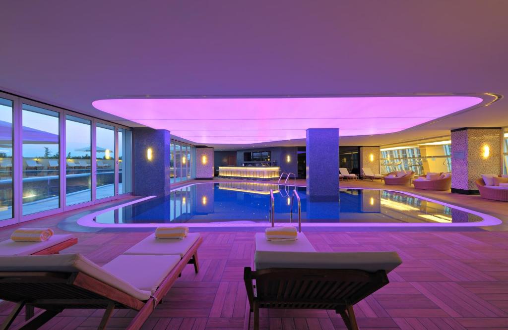 巴统巴统丽笙酒店的酒店大堂设有紫色照明的游泳池