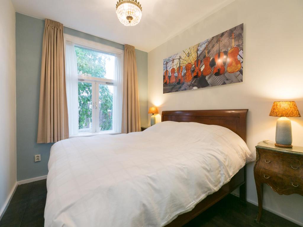 海牙The Sunny Suite - R.Q.C.的卧室配有白色的床和窗户。