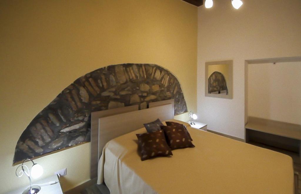 圣斯特凡诺迪卡马斯特拉Casa Vacanze Camastra的一间卧室配有一张大床和石制床头板