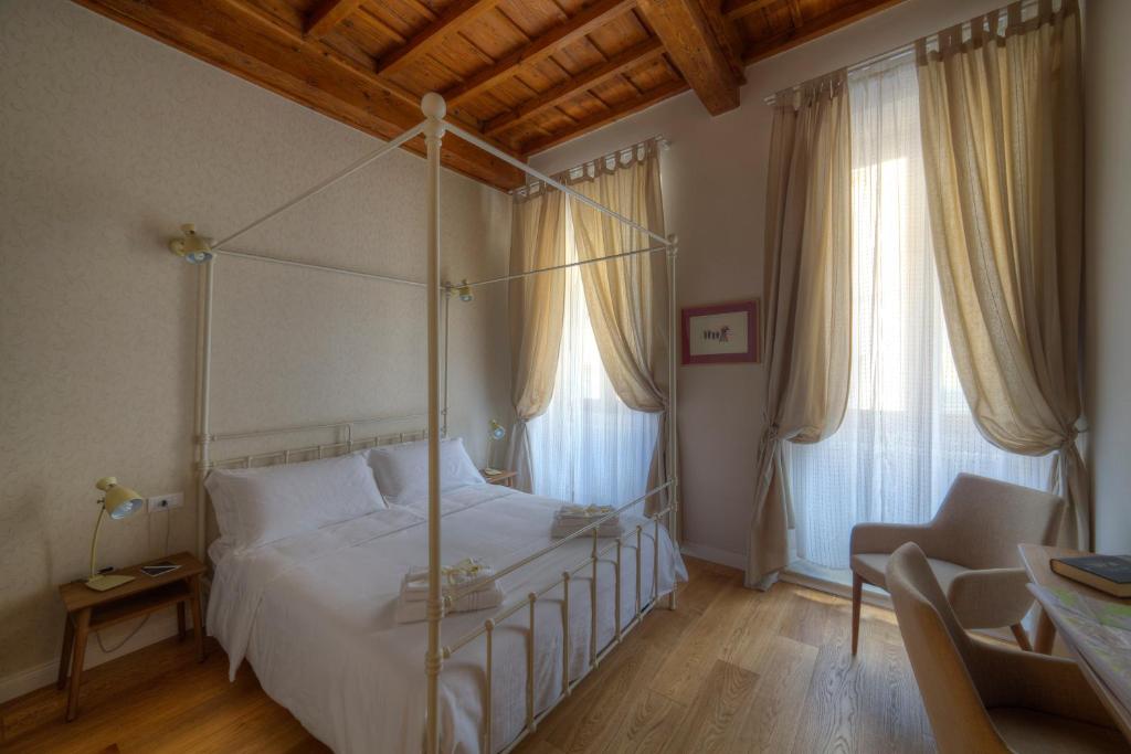 佛罗伦萨阿萨波拉特住宿加早餐旅馆的一间卧室设有天蓬床和2个窗户