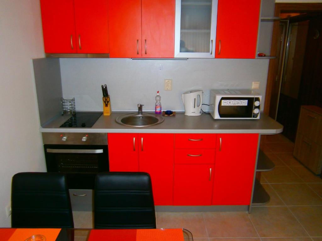 帕莫瑞Apartament Stefi II的一间带红色橱柜和水槽的厨房