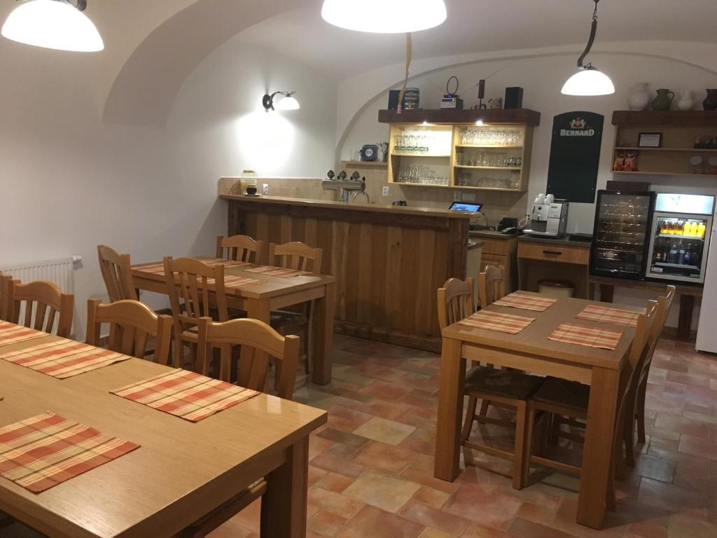 BohušicePenzion Bednářův dvůr的餐厅设有木桌、椅子和柜台