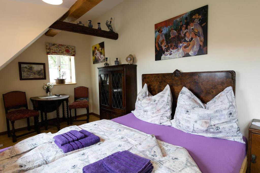赫日布斯卡1876怀乡旅馆的一间卧室配有一张带紫色床单和枕头的床。
