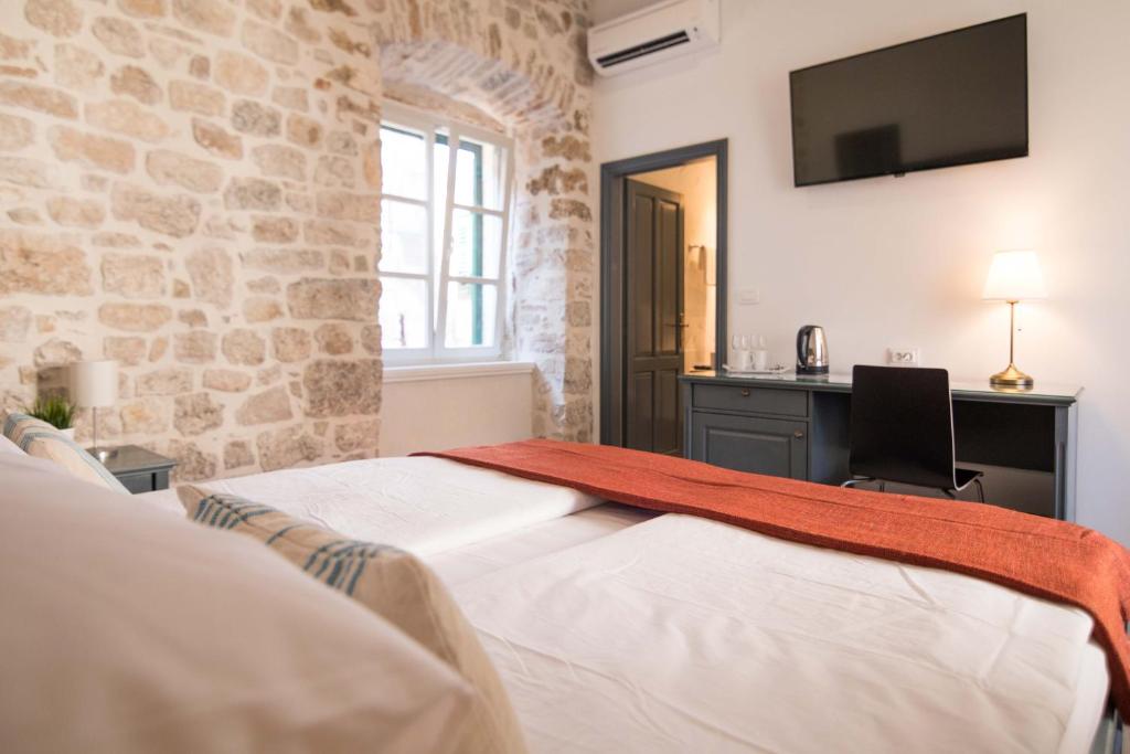 希贝尼克地中海豪华客房旅馆的一间卧室配有一张床、一张书桌和一台电视。