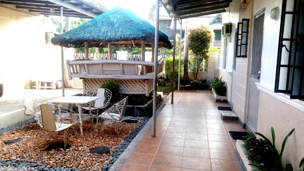 BalangaBTH Traveller's Home的庭院配有桌椅和遮阳伞。