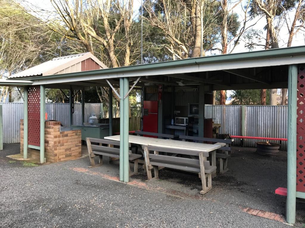 Heywood松木大篷车公园露营地的棚下的野餐桌和长凳