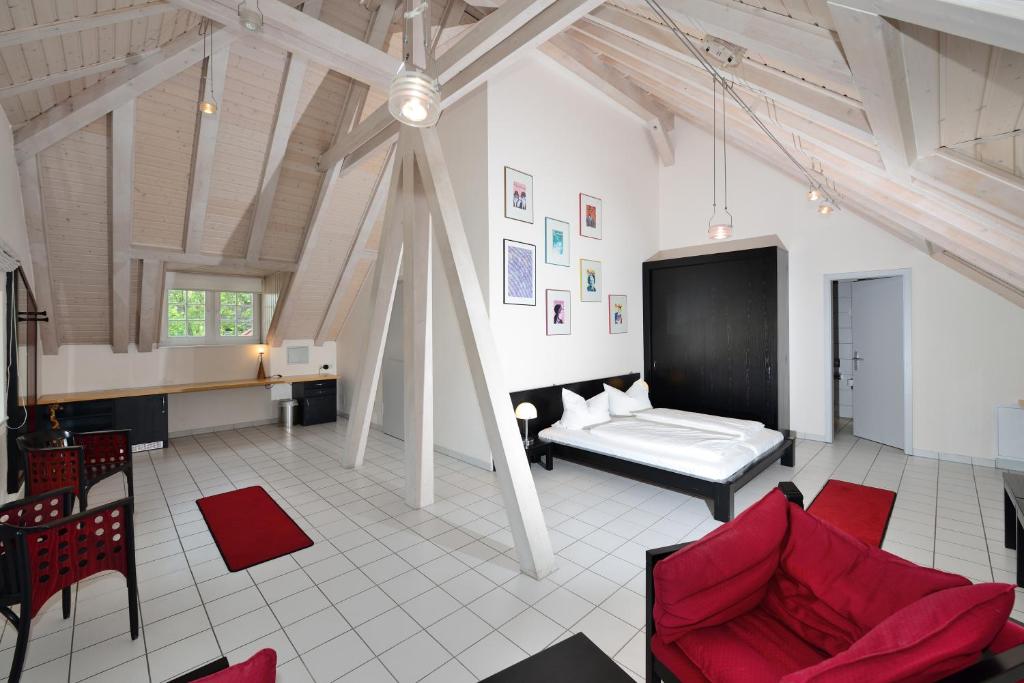 魏玛魏玛艺术酒店的客厅配有床和红色椅子