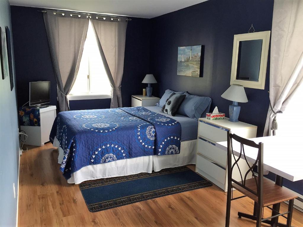 库德尔岛Gîte du Moulin的蓝色的卧室设有床和窗户