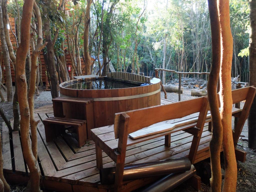 拉恩塞纳达Cabañas Ensenada Bosque Nativo的木制甲板设有热水浴池和2个长椅