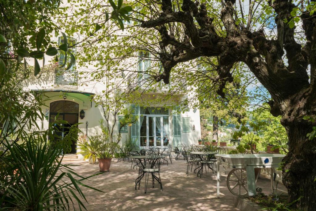 格拉斯贝劳迪耶酒店的树下带桌椅的庭院