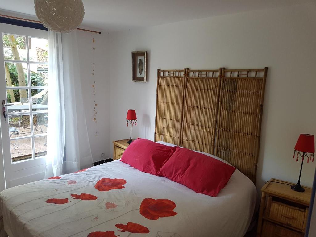 派拉索梅阿卡巴别墅酒店的一间卧室配有一张带红色床单的床和一扇窗户。