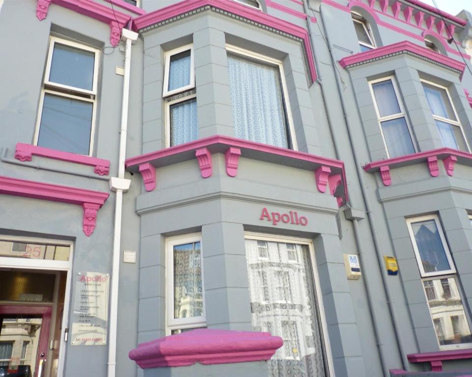 海斯廷斯Apollo Guest House的粉红色和灰色的建筑,上面有花旗