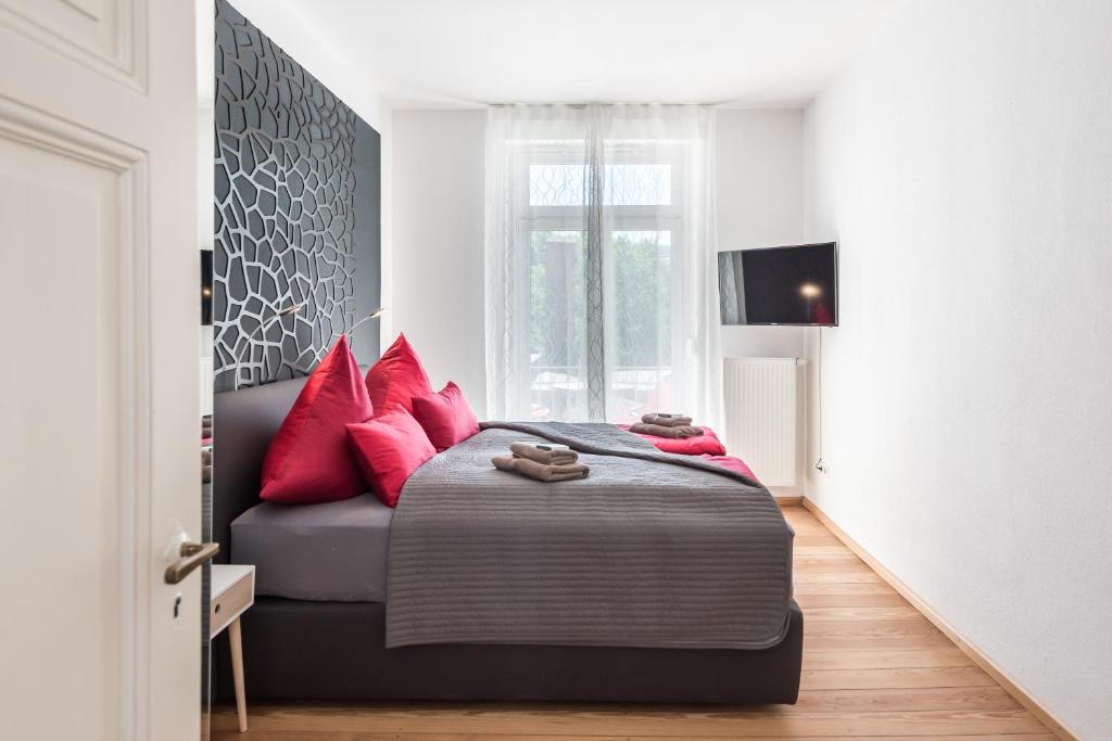 弗莱堡Family-Apartments Freiburg的一间卧室配有一张带红色枕头的床和一张沙发