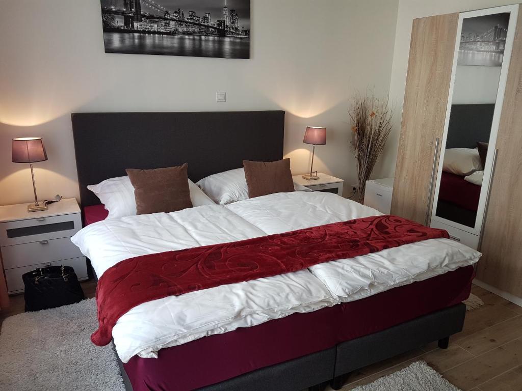 科隆艾根史坦酒店的一间卧室配有一张带红色和白色床单的大床