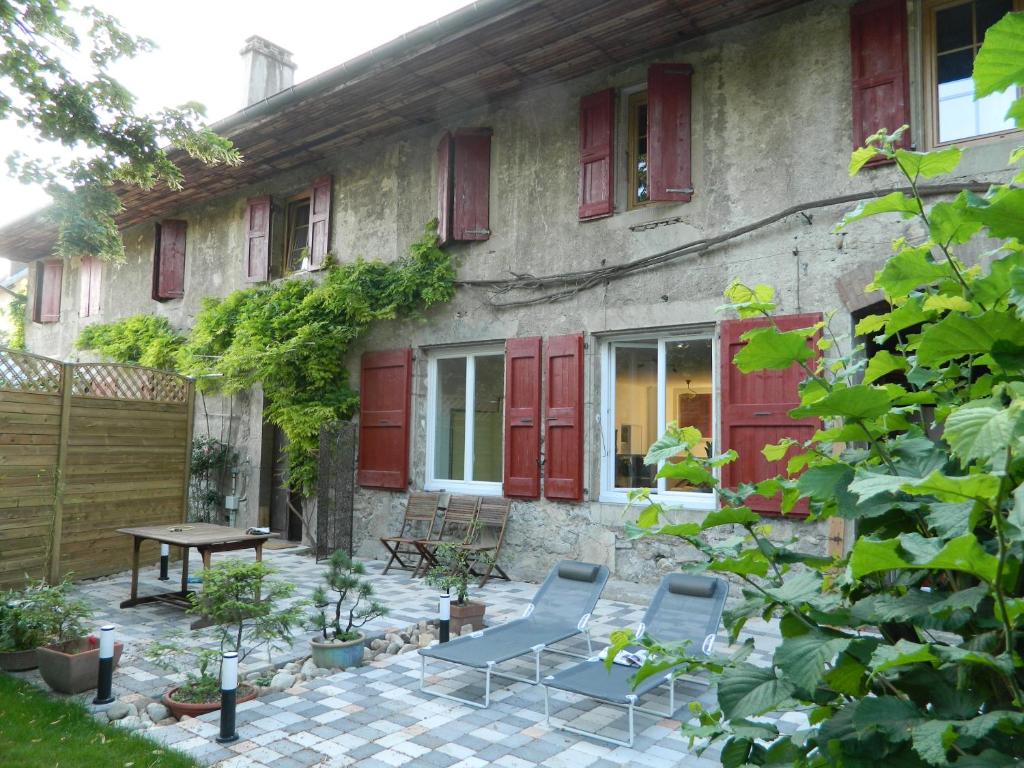 BarbyGite de l'école的院子里有红色门和椅子的房子