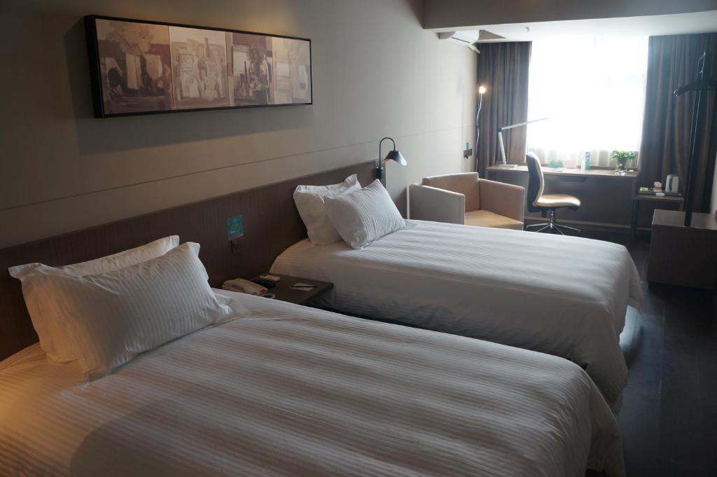 海口锦江之星海口国贸金龙路店的酒店客房,配有两张床和椅子