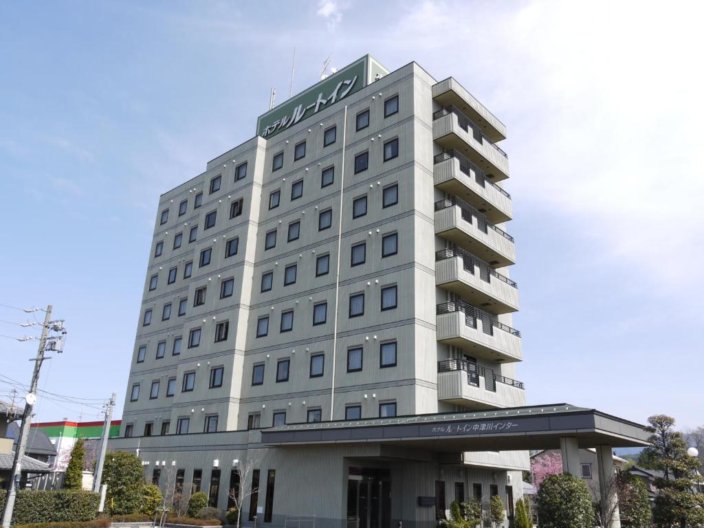 中津川市中津川国际铁路酒店的一座高大的白色建筑,上面有标志