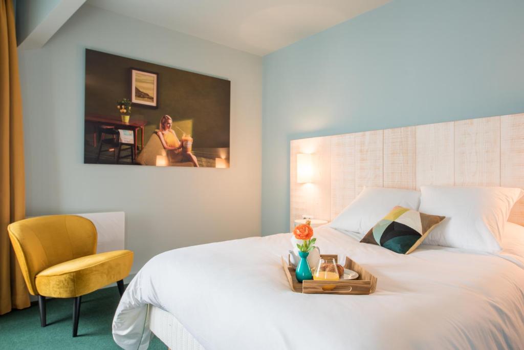 博讷乐中心精品酒店的卧室配有一张白色的床、一张桌子和一把椅子