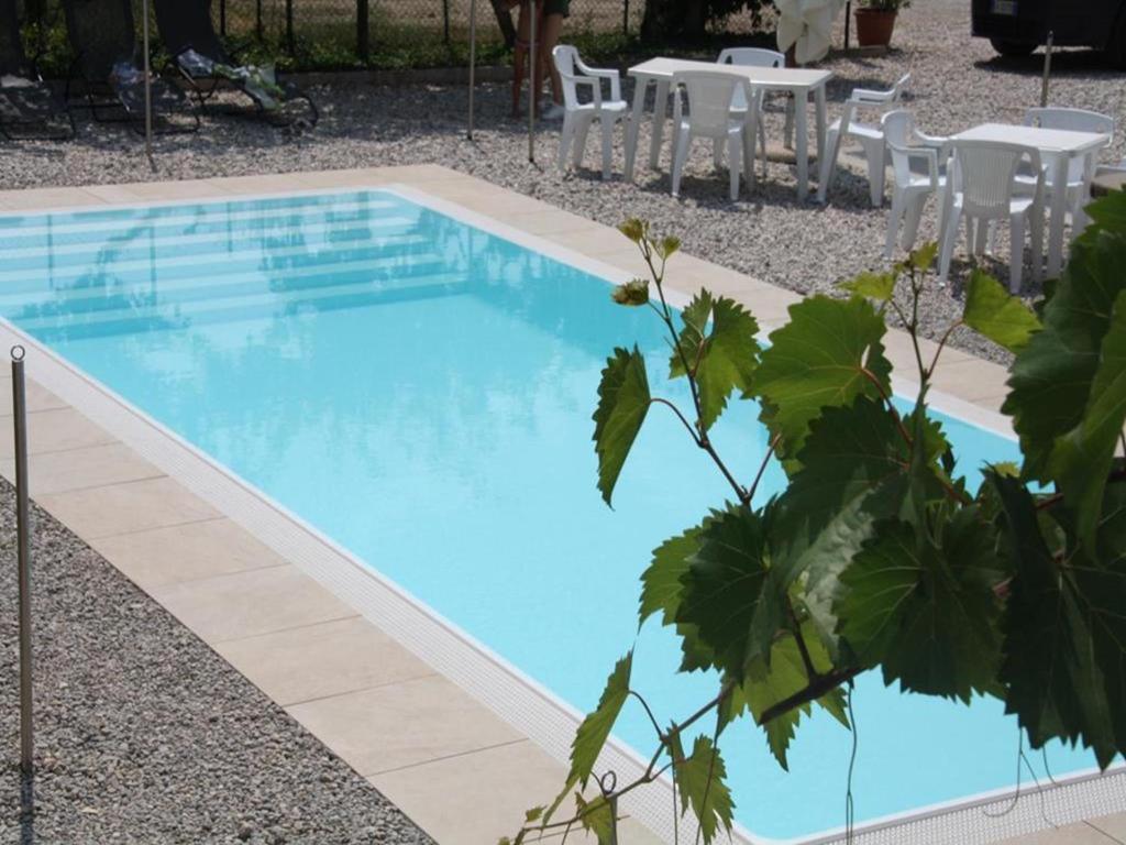 阿科Appartamenti Gardastivo的一个带桌椅的蓝色游泳池