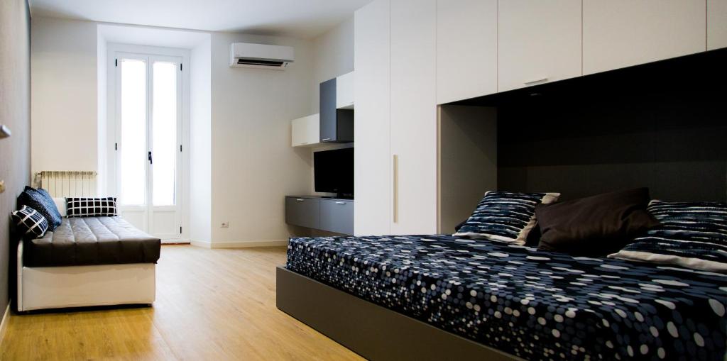 米兰纳维吉利P&D公寓的一间卧室配有一张大床和一张沙发