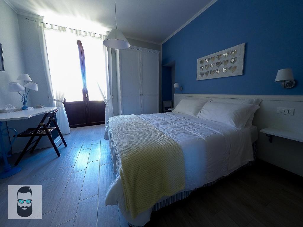 马拉泰亚ReginElena B&B的一间卧室配有一张床、一张书桌和一个窗户。
