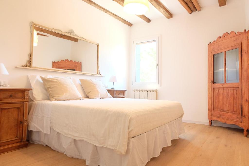 威尼斯Casa Mongolfiere Venezia的卧室配有一张大床,墙上装有镜子