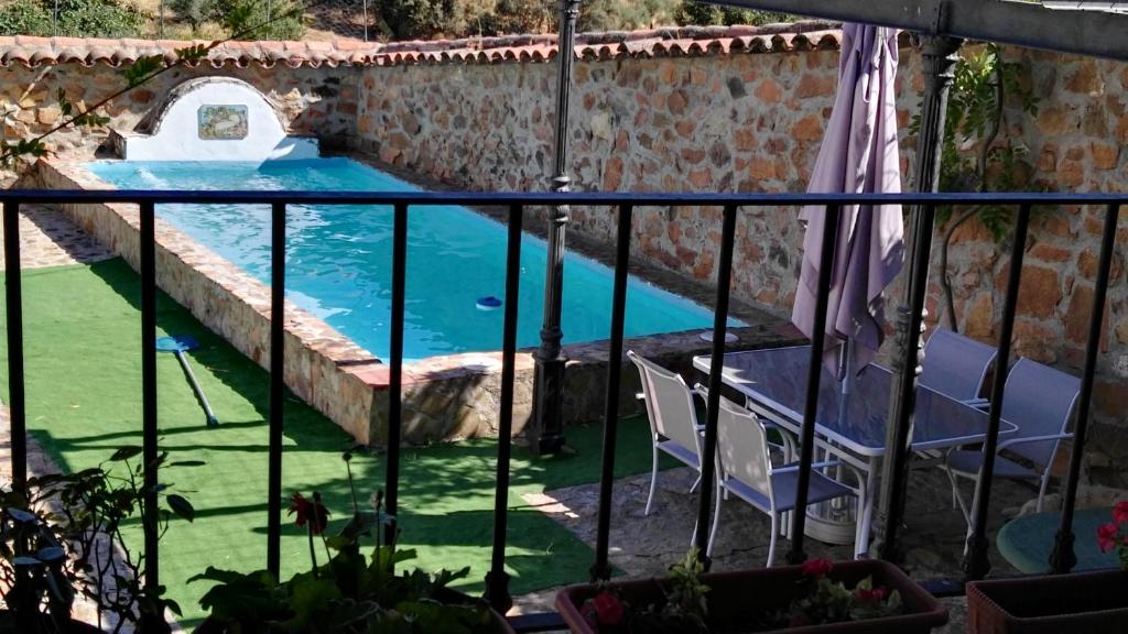 El AlcornocalCasa Rural EL Trillo的从房子的阳台上可欣赏到游泳池的景色