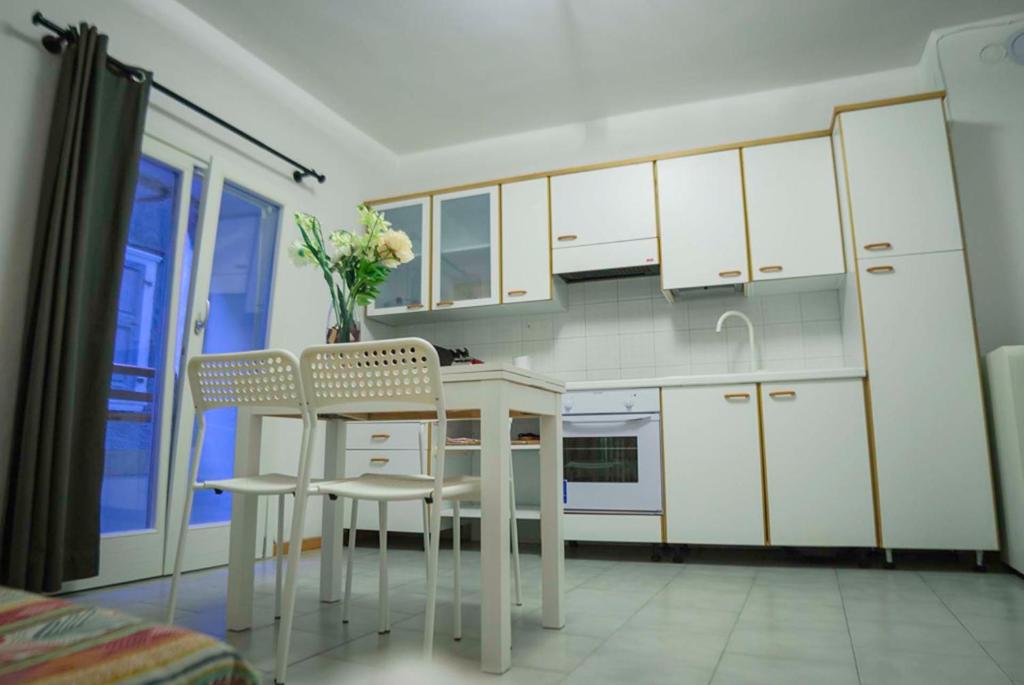 滕诺SleepinGarda的厨房配有白色橱柜和桌椅