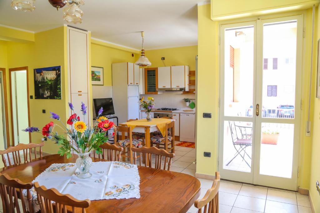 乌尔巴尼亚A casa di Franci的厨房以及带鲜花桌的用餐室。