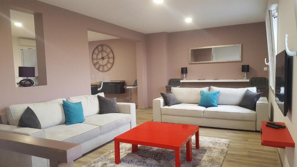 埃佩尔奈La Villa Geiss的客厅配有2张白色沙发和1张红色桌子