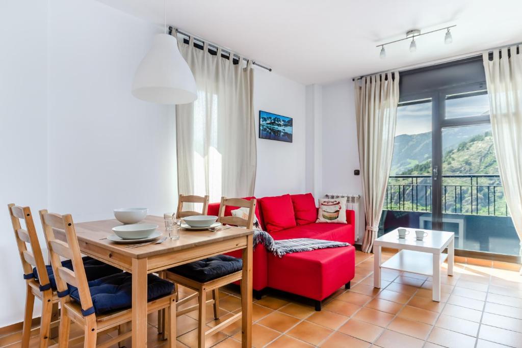 索尔德乌Apartamentos Prat de les Molleres的客厅配有桌子和红色沙发