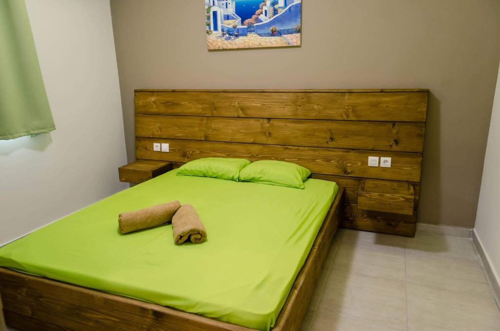 法里拉基Maestro Apartments Faliraki的一张带绿床单的床和两张毛巾
