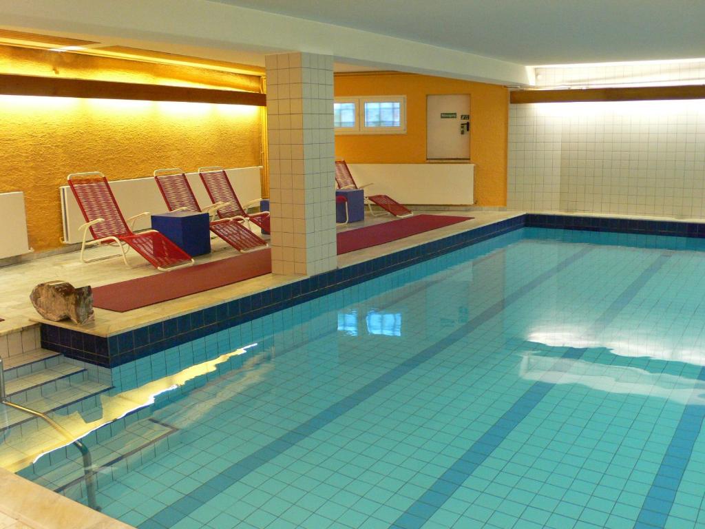 萨尔布吕肯梅兰海伦巴德萨那温泉酒店的一个带椅子的大型游泳池