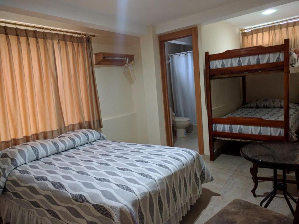 萨利纳斯Hotel Mileto的一间卧室配有一张床和一张双层床。