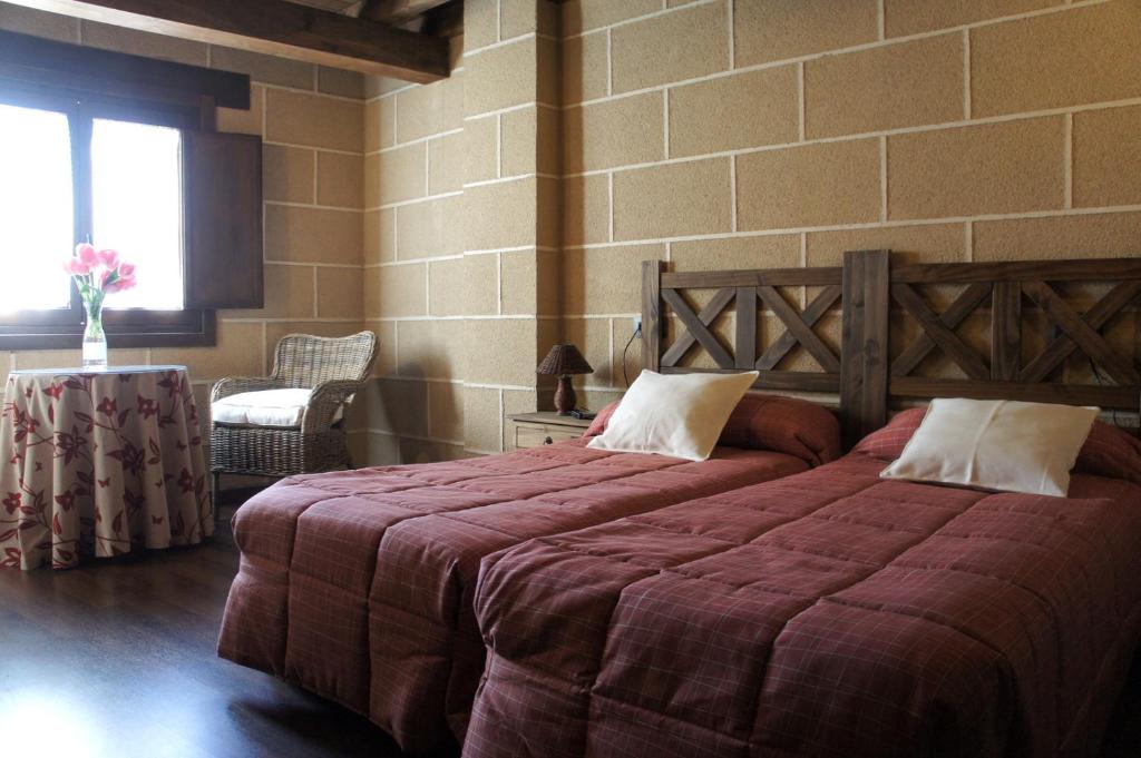 圣马尔廷德特雷韦霍Casa Rural Estrela的一间卧室设有两张床和砖墙