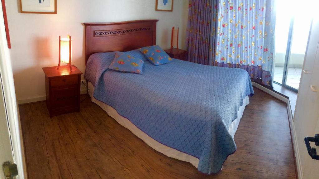 阿尔加罗沃San Alfonso del Mar Resort的一间卧室配有一张床和一盏灯,铺有木地板