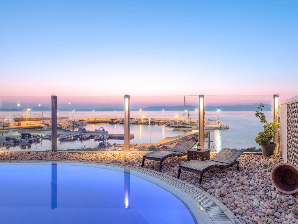 马蒂卡波韦德酒店的一个带长椅的游泳池,享有海港的景色