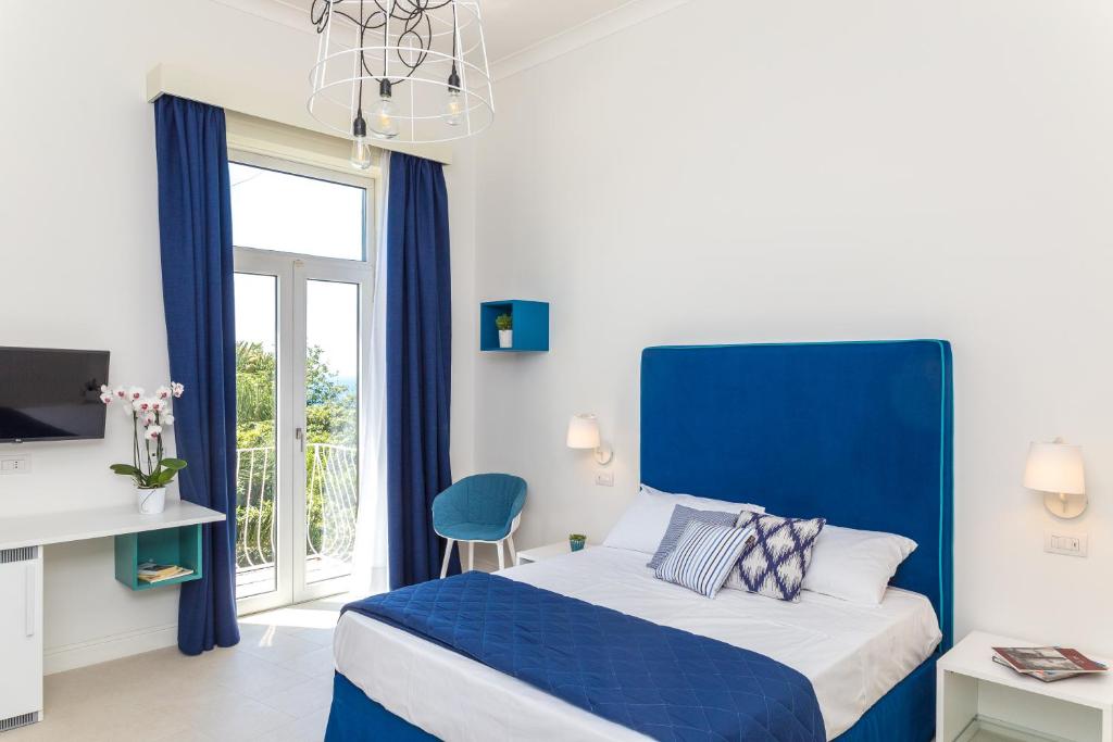 梅塔Maison Ro'的蓝色和白色的卧室设有床和窗户