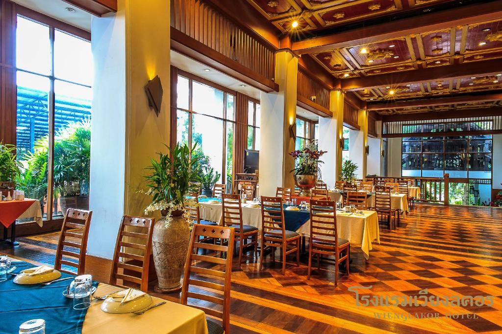 南邦南邦维拉科酒店的一间设有桌椅的餐厅,位于带窗户的房间内