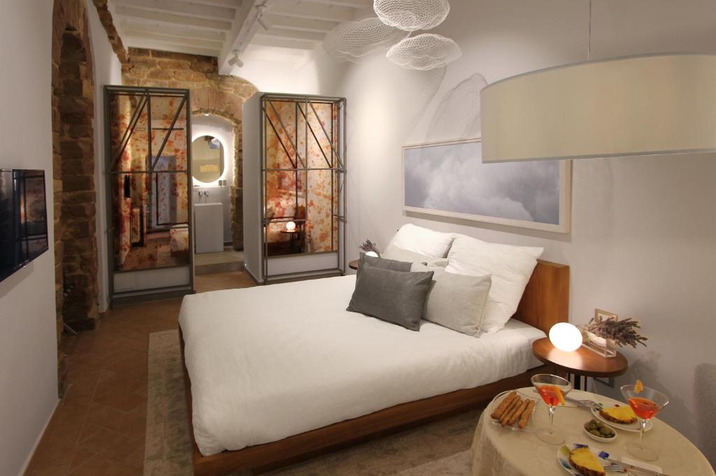 佛罗伦萨领主广场迪勒旅馆的卧室配有一张白色的大床和两张桌子