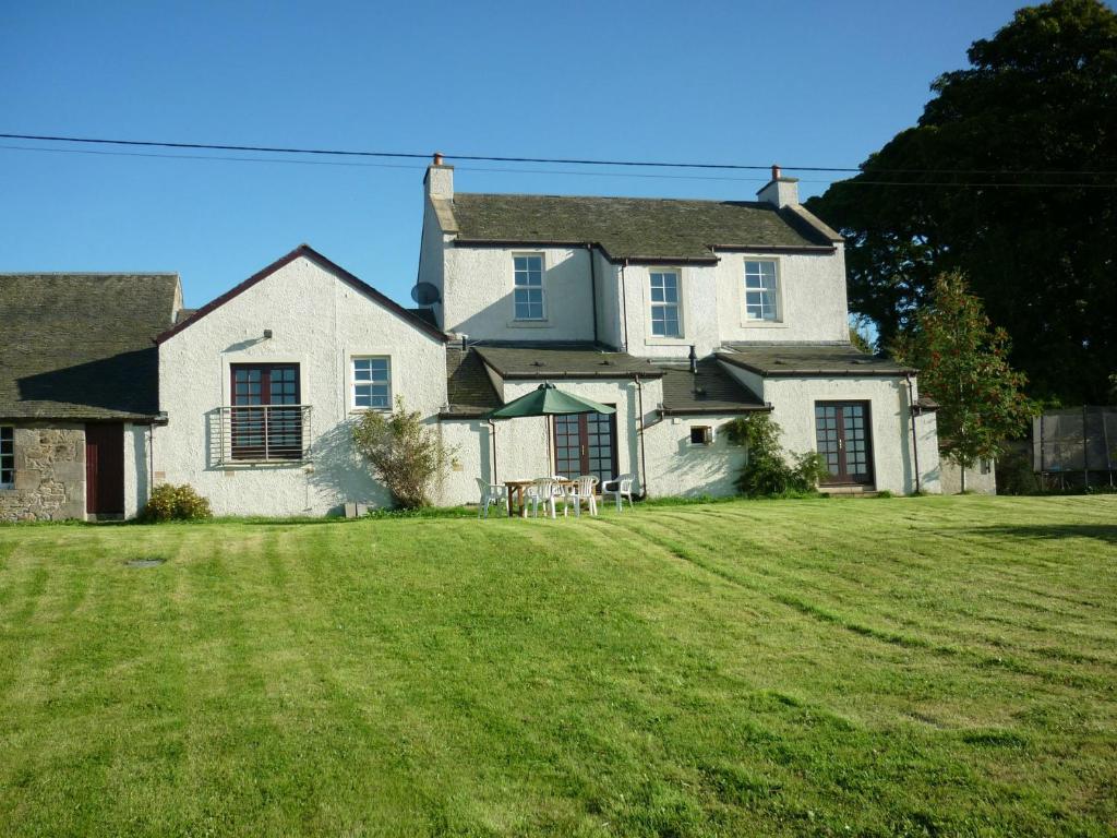 爱丁堡Midkinleith Farm Holiday Cottage的一座大型白色房子,设有大院子