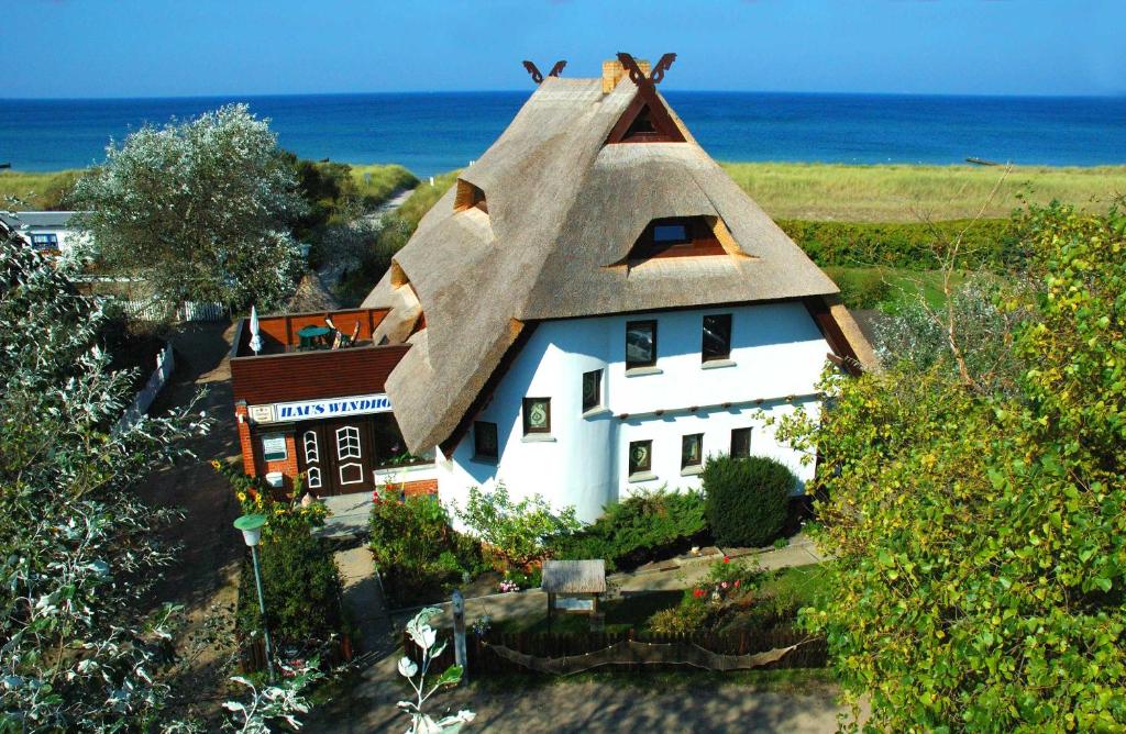 奥茨塞巴德·迪尔哈根Haus Windhook的白色的小房子,带有茅草屋顶