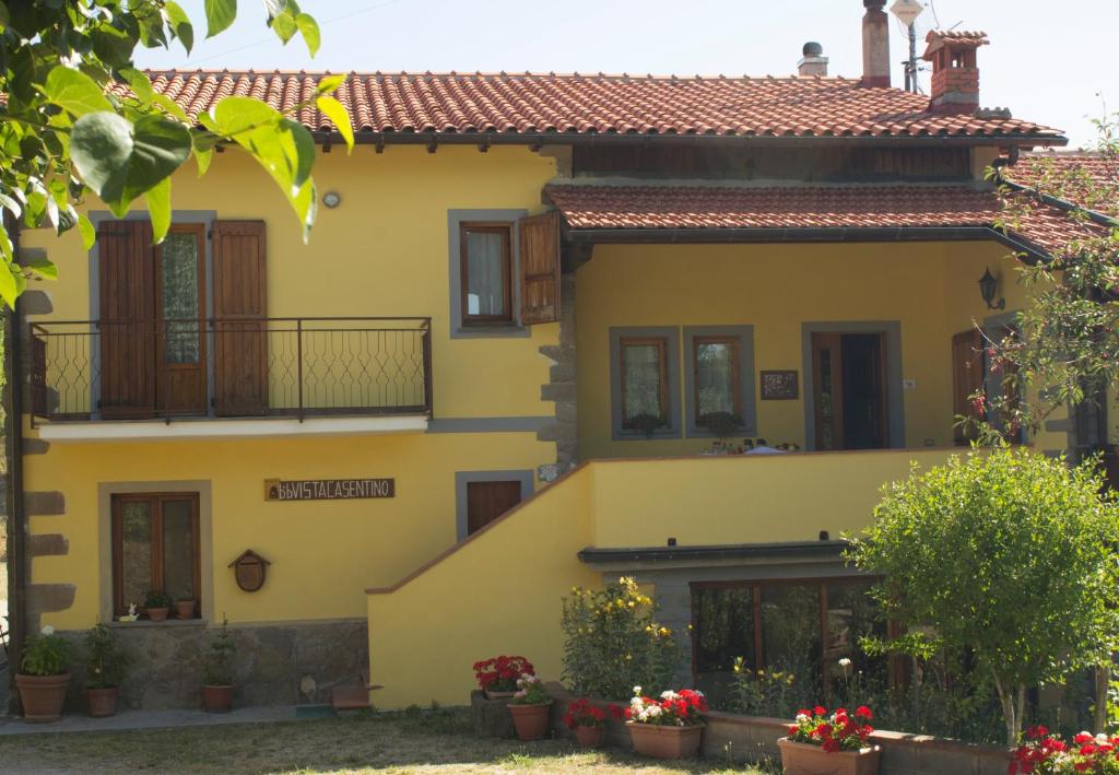 普拉托韦基奥B&B Vista Casentino的前面有鲜花的黄色房子