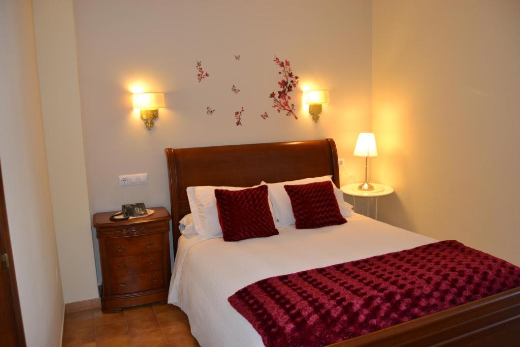 波多诺伏Hotel Nuevo Cachalote的一间卧室配有一张带红色枕头的大床
