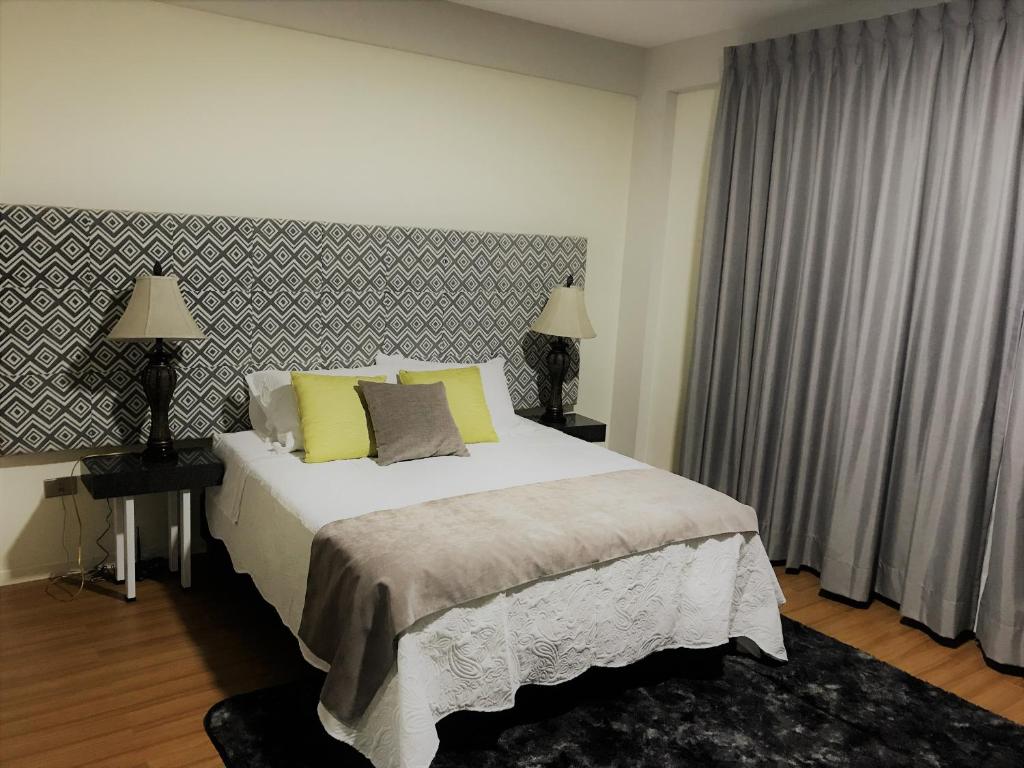 科恰班巴Departamento De Lujo的一间卧室配有一张带黄色枕头的大床