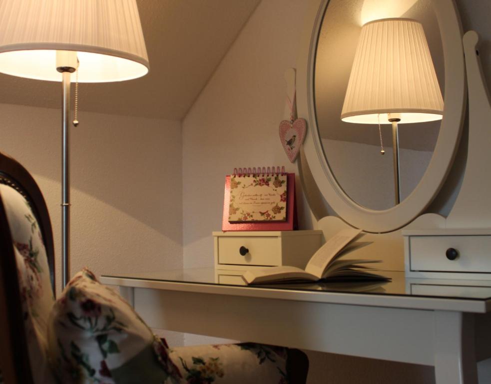 霍恩巴赫格鲍尔旅馆的一张带镜子的桌子和一把带书籍的椅子